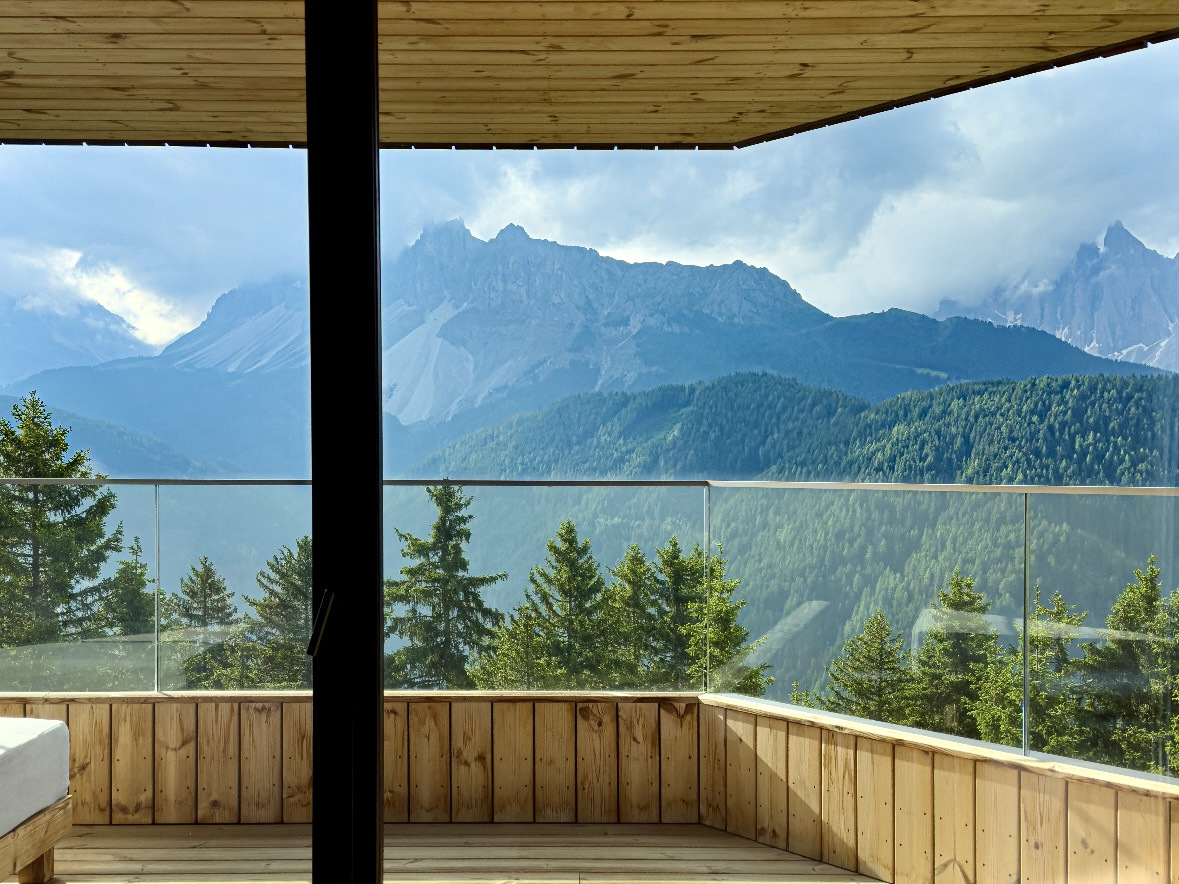 Timber guest suite opening onto a mountain terrace in a design led tourism property